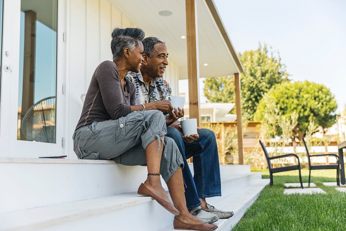 Couple having coffee on their porch.