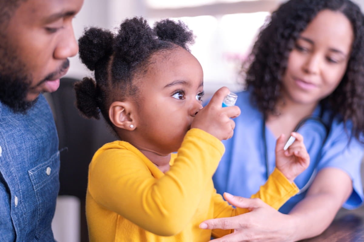 girl with parents using an inhaler.