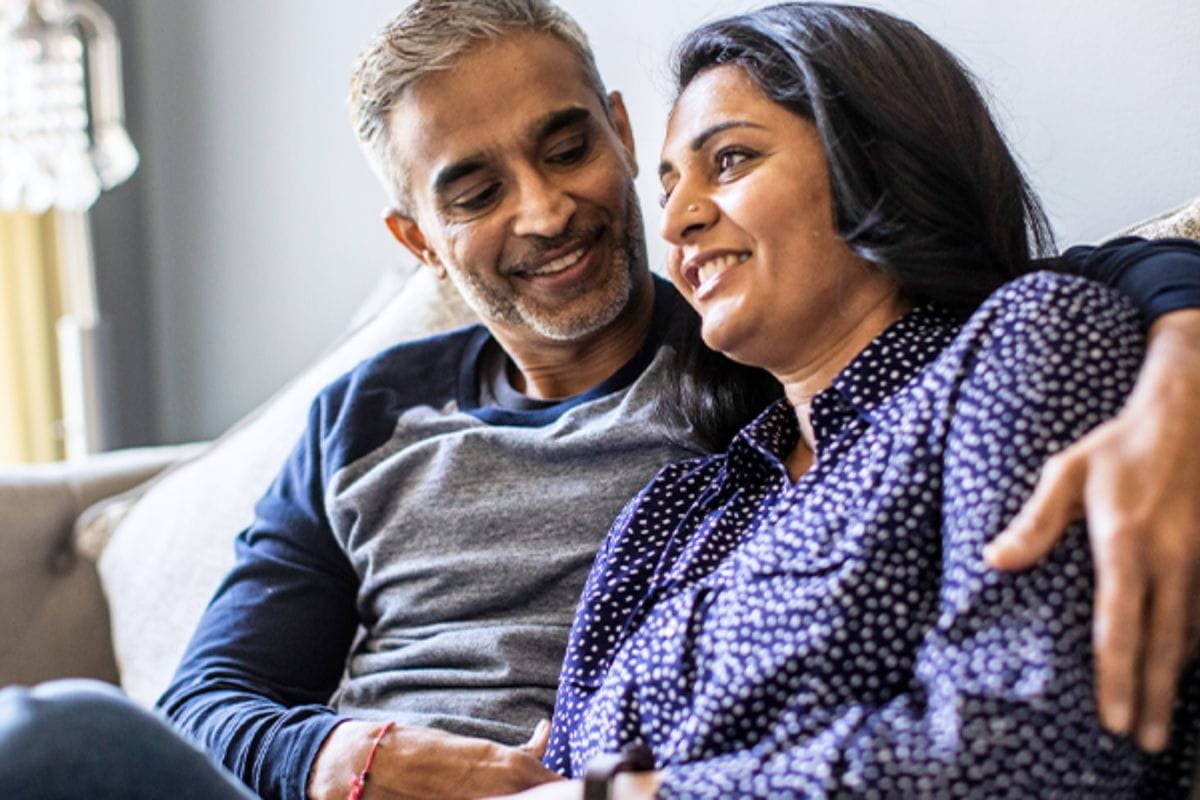 Middle aged man and woman discuss the importance of health screenings with their doctor at Ascension