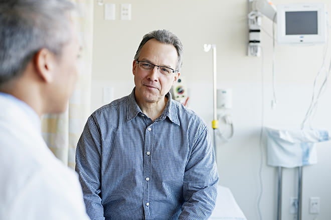 Older man talking with an orthopedic doctor about getting joint replacement at an Ascension site of care.