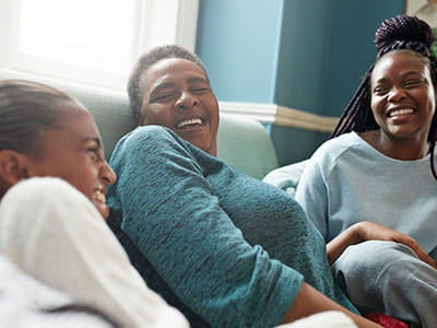 Mom and daughters laughing on couch