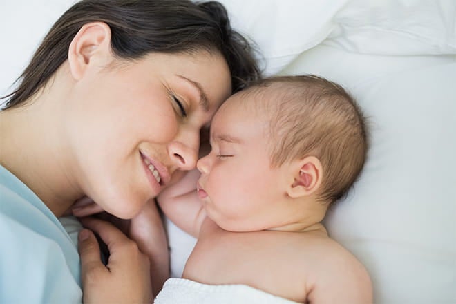 Newborn baby and mother snuggling. 