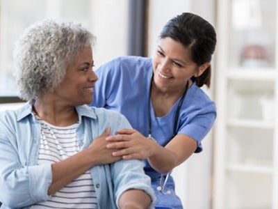 Woman visits with her nurse at an Ascension site of care.