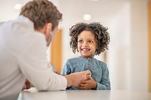 A doctor is using a stethoscope to listen to a child's heartbeat.