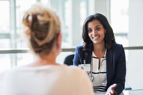 A woman talking to an ob-gyn doctor.